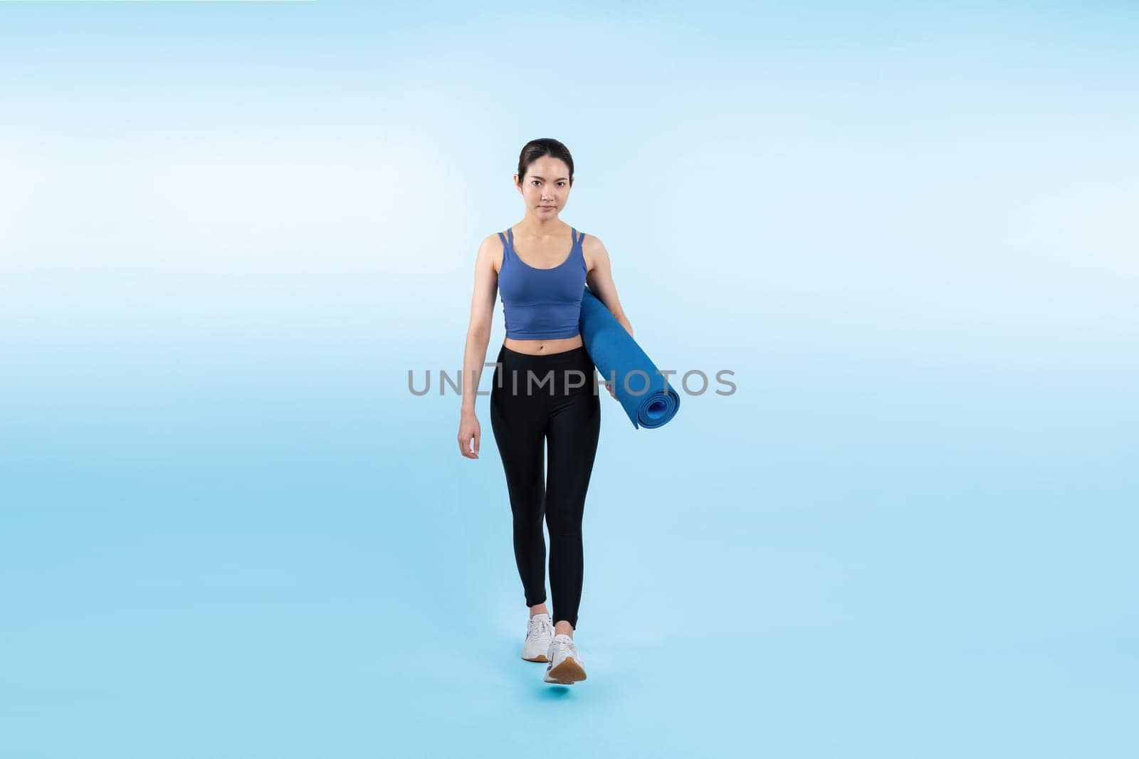 Young attractive asian woman portrait in sportswear with exercising mat. Healthy exercise and workout routine lifestyle concept. Studio shot isolated background. Vigorous