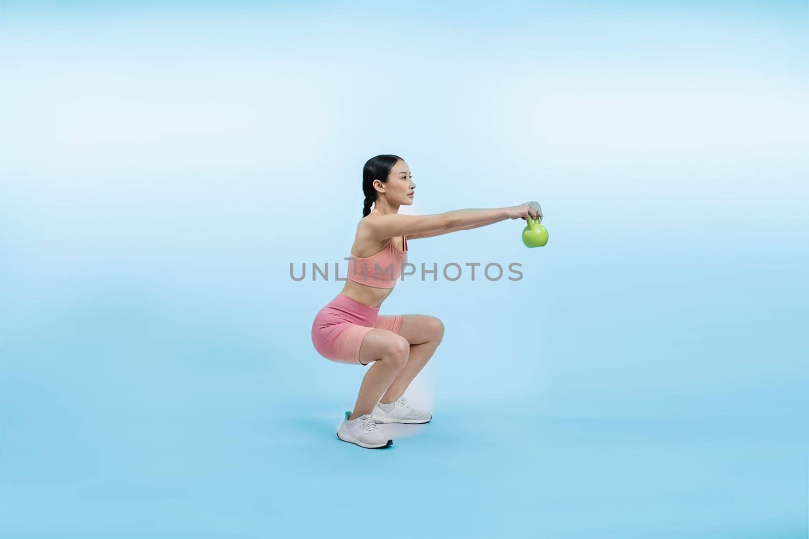 Vigorous energetic woman doing yoga with kettlebell weight exercise. by biancoblue