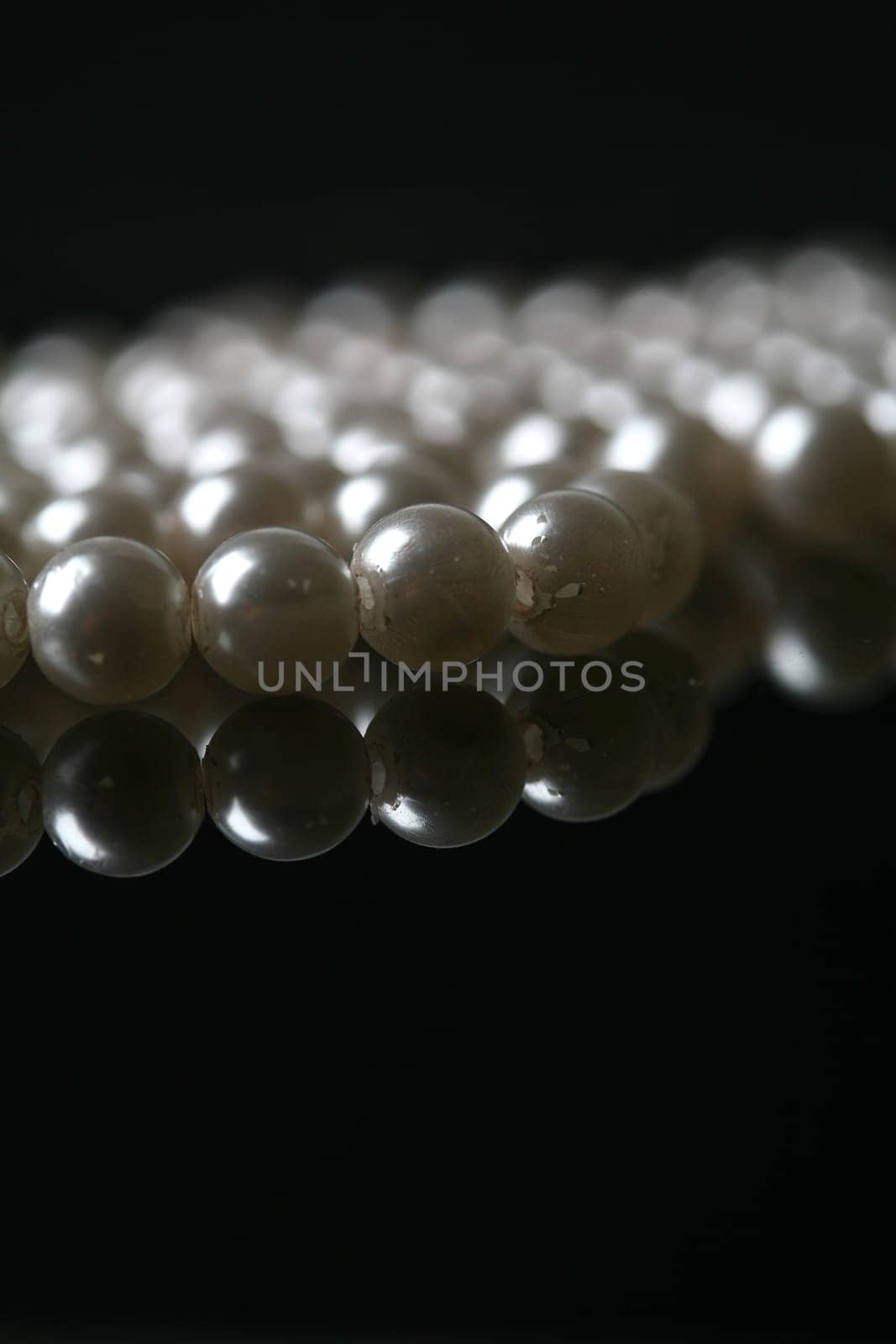 Beautiful white pearl necklace over black background