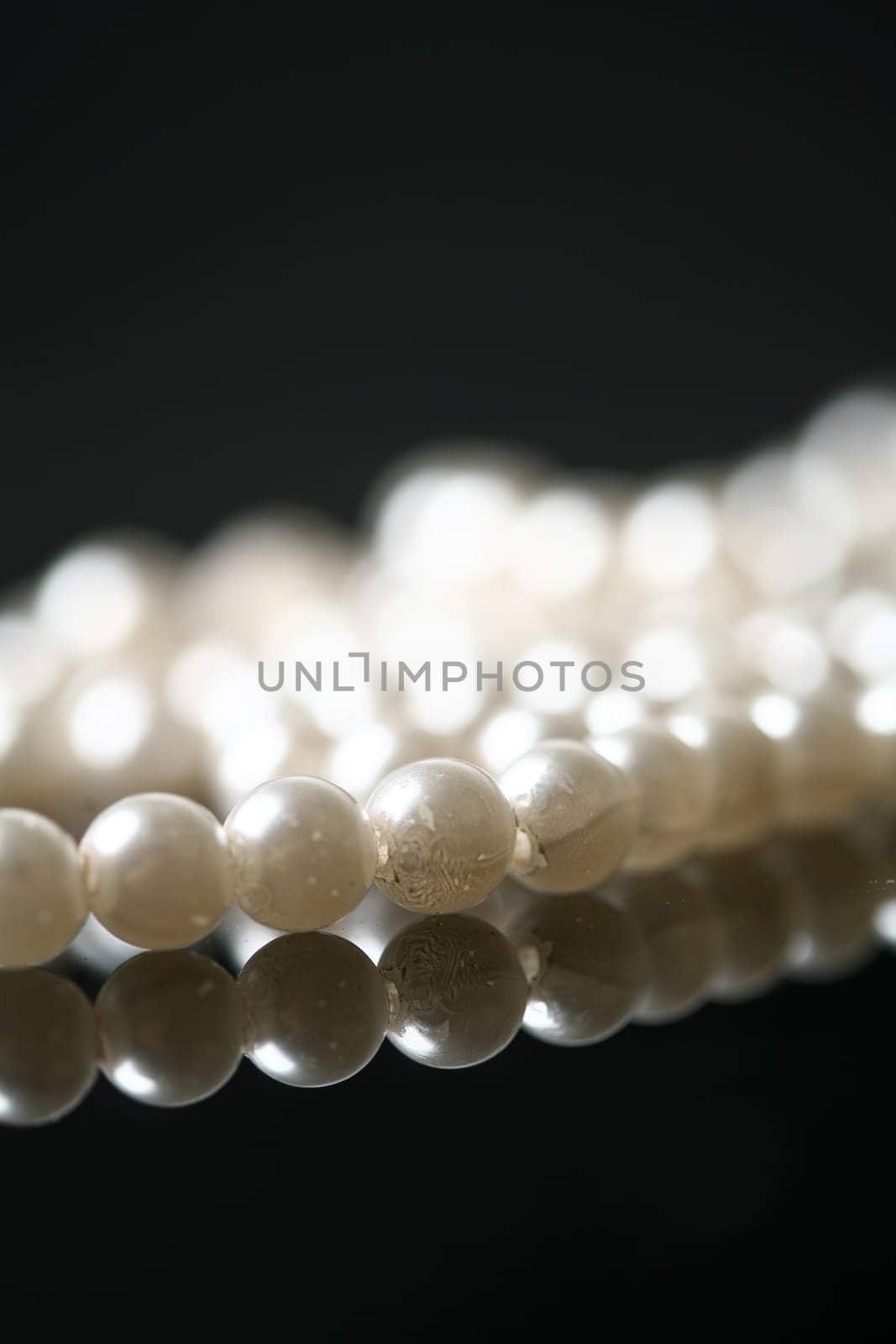 Beautiful white pearl necklace over black background