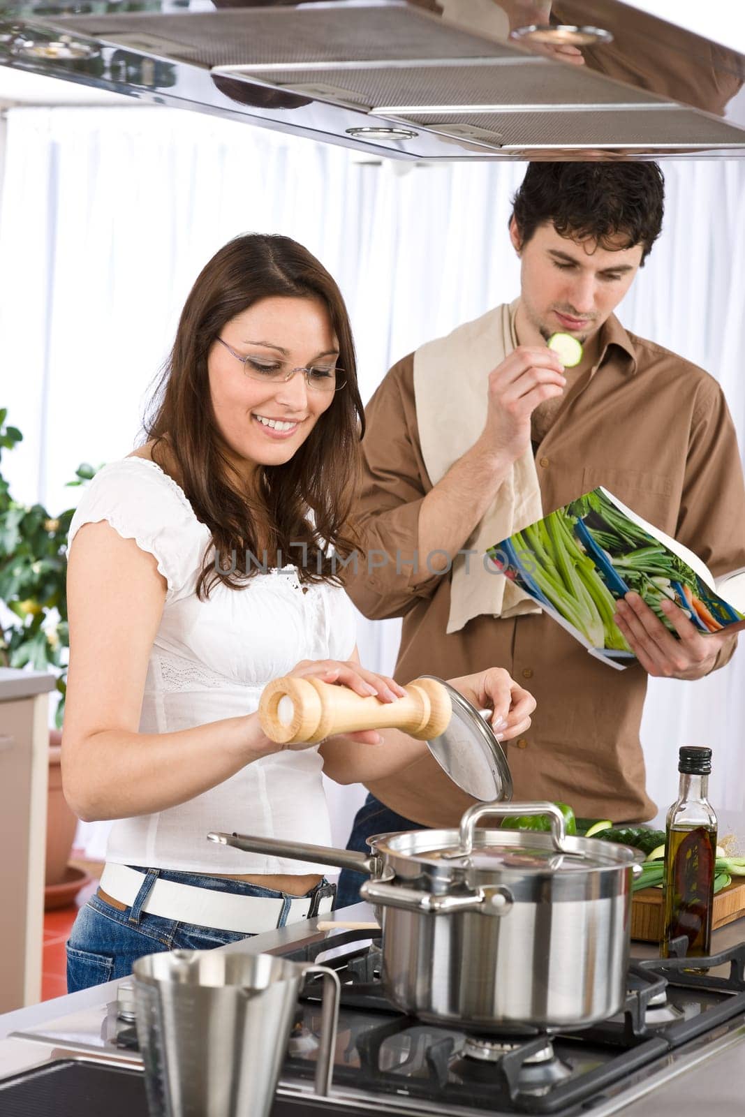 Happy couple in modern kitchen cooking