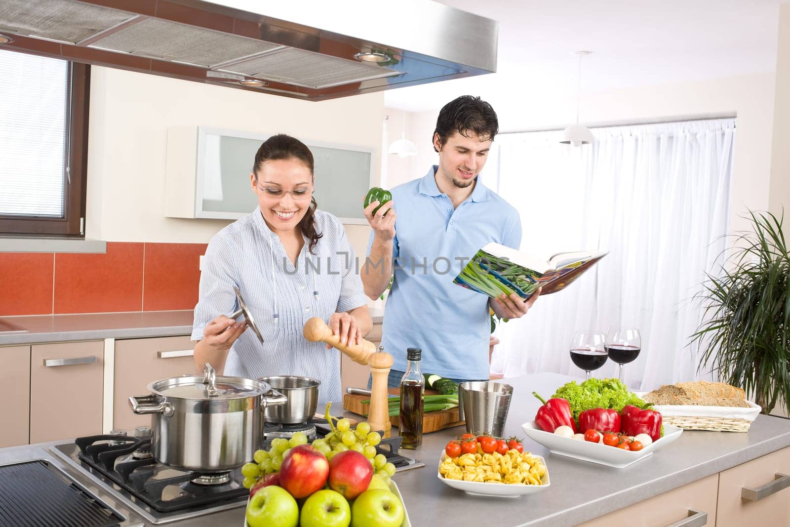 Happy couple in modern kitchen cooking