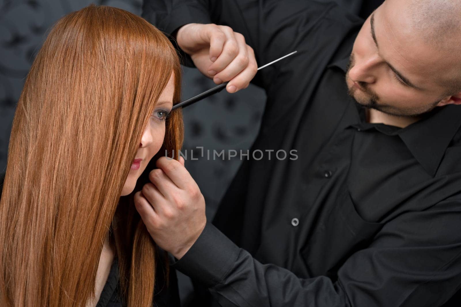 Professional hairdresser with fashion model at luxury salon
