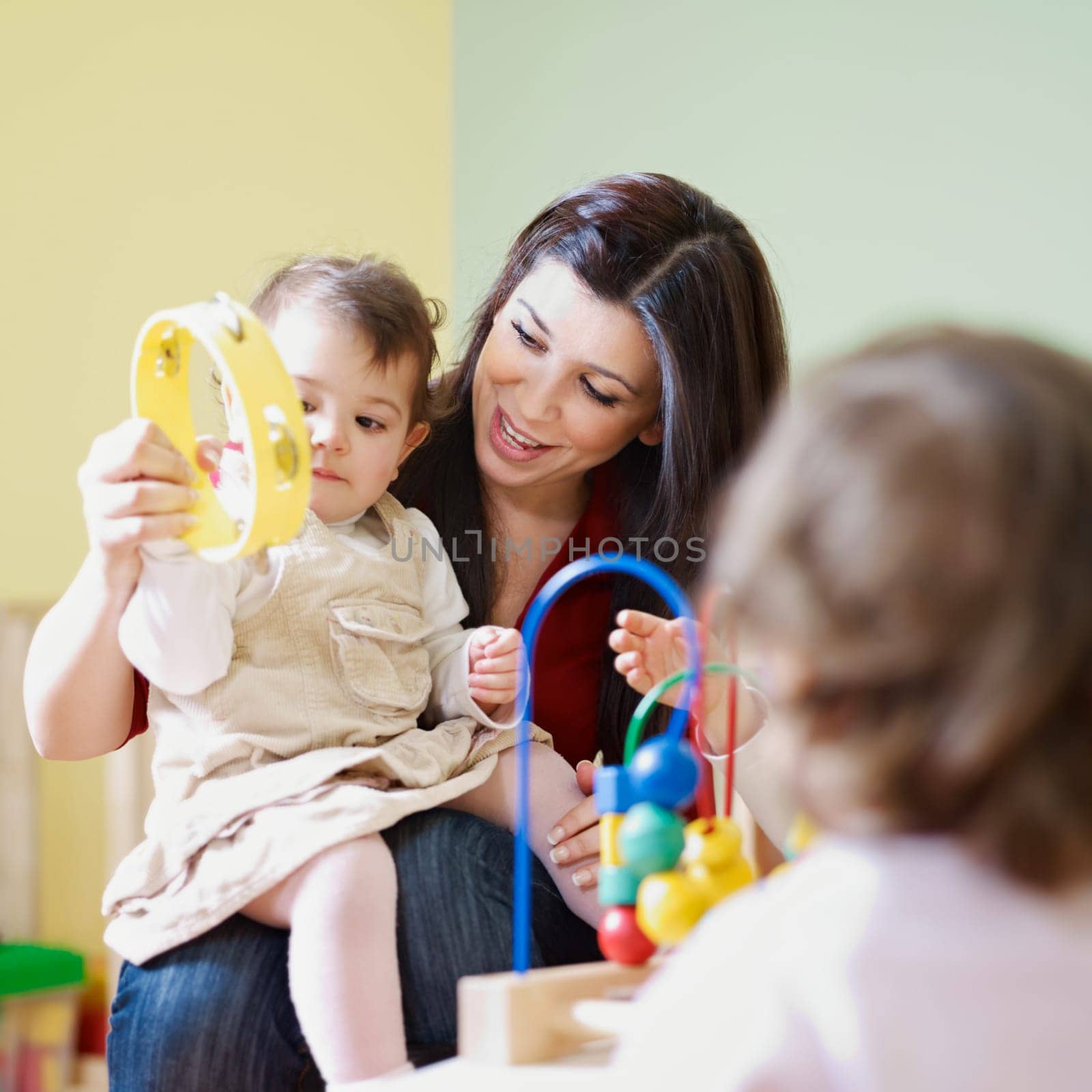three little girls and female teacher in kindergarten