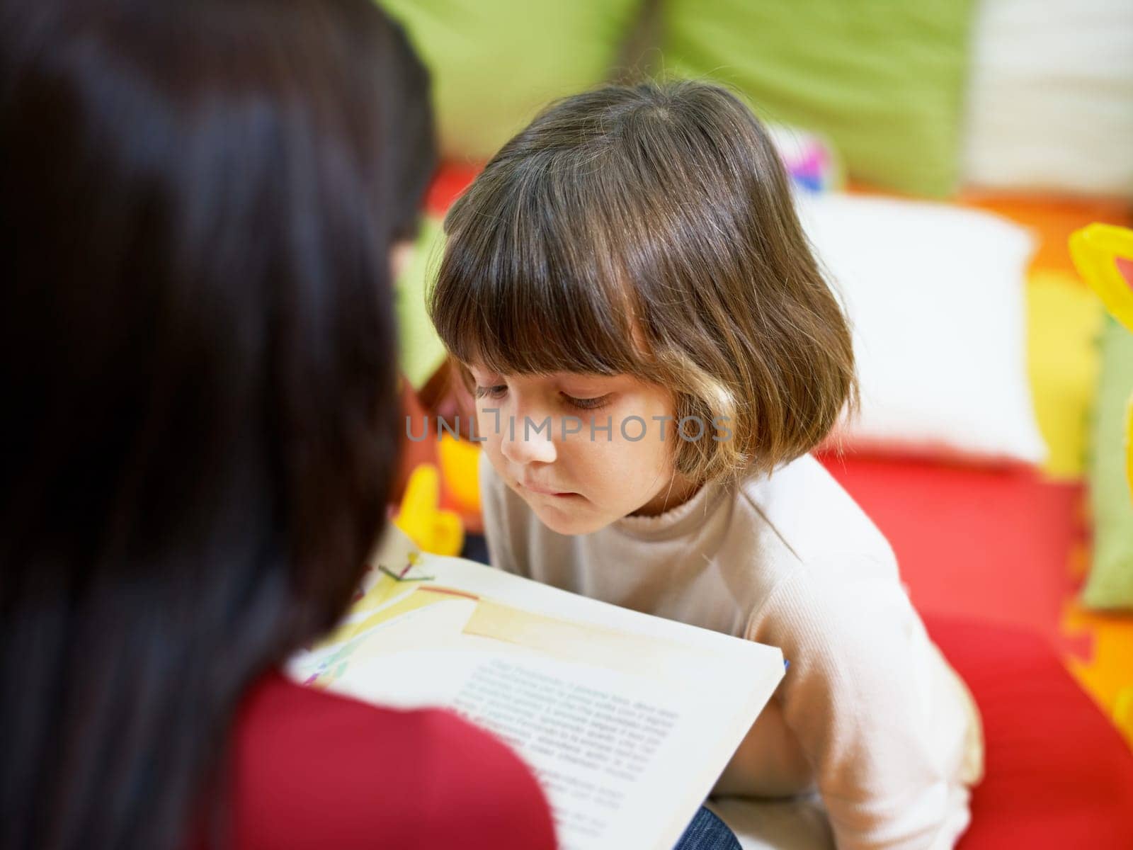 three little girls and female teacher in kindergarten