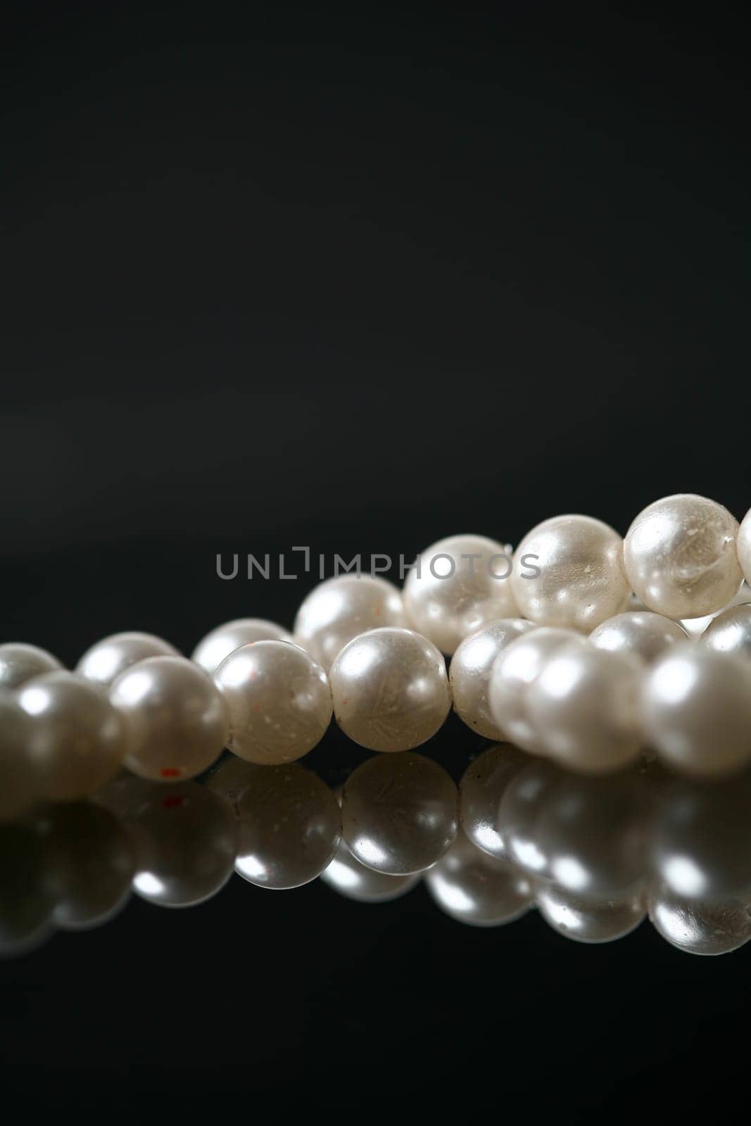 Beautiful white pearl necklace over black background