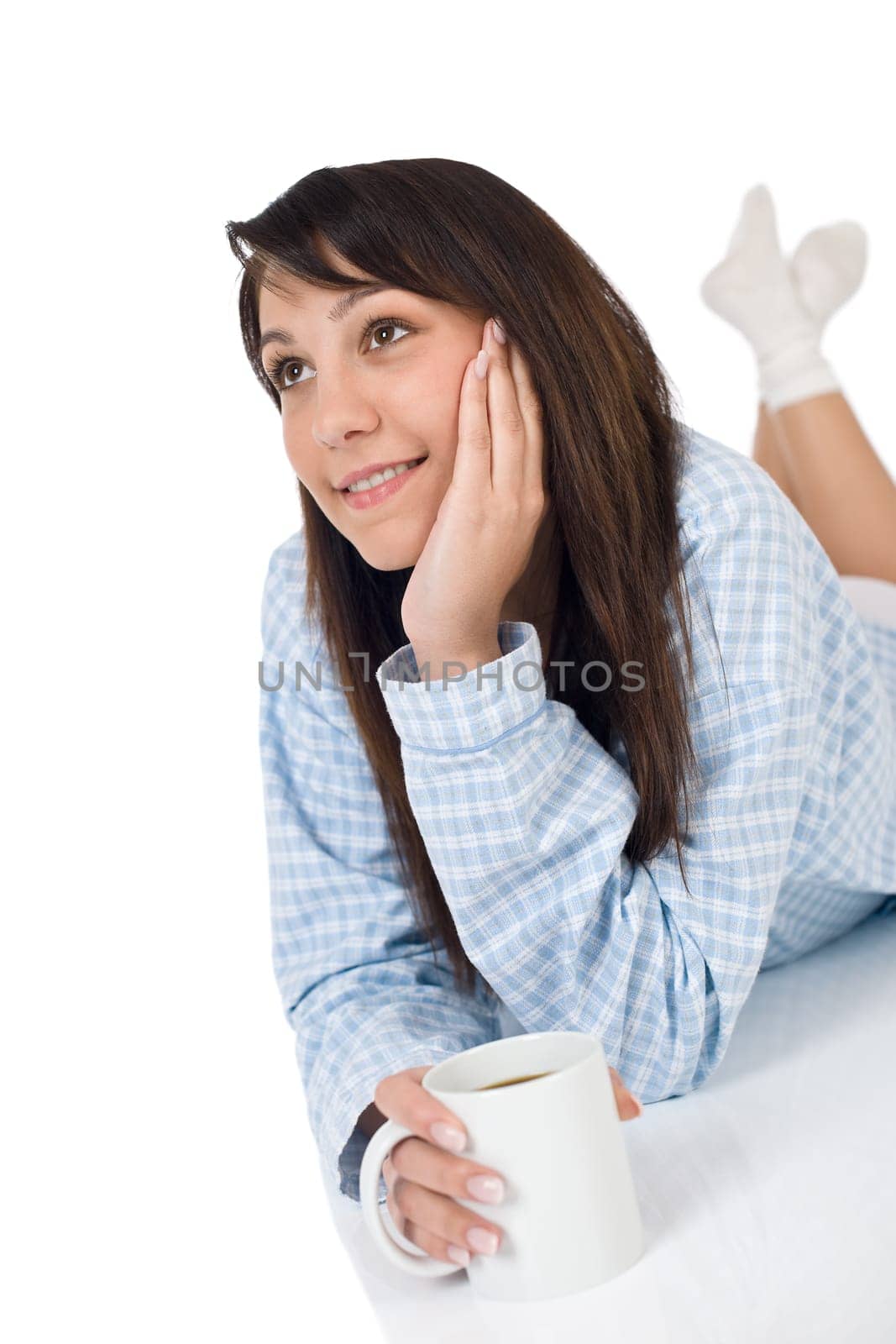 Happy young woman with coffee in pajamas