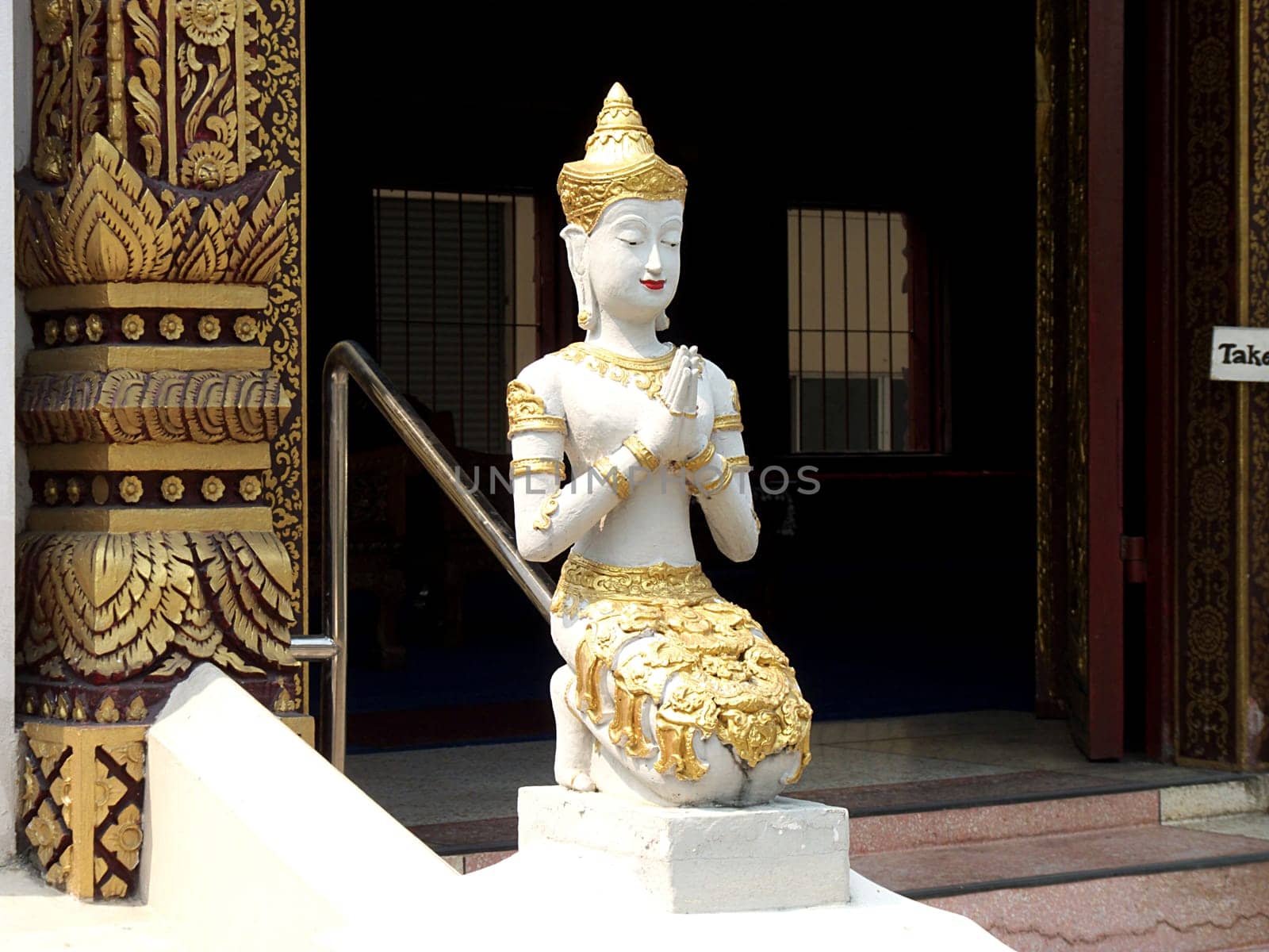 Praying figure in front of a temple