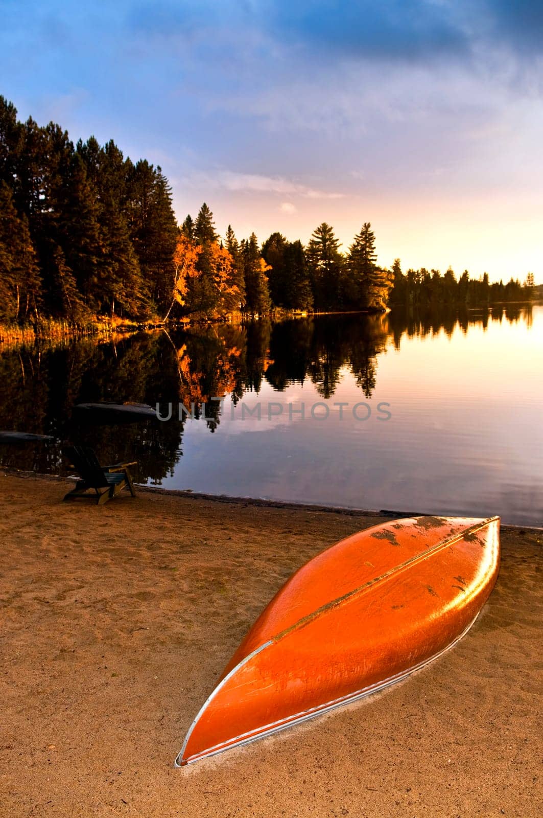Lake sunset with canoe on beach