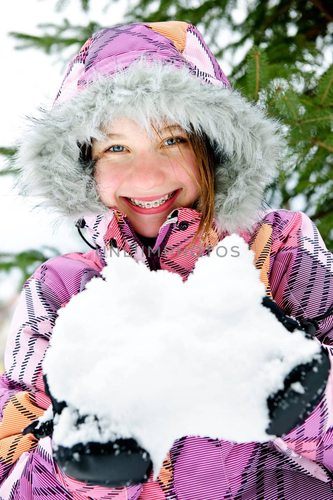 Happy winter girl holding snow