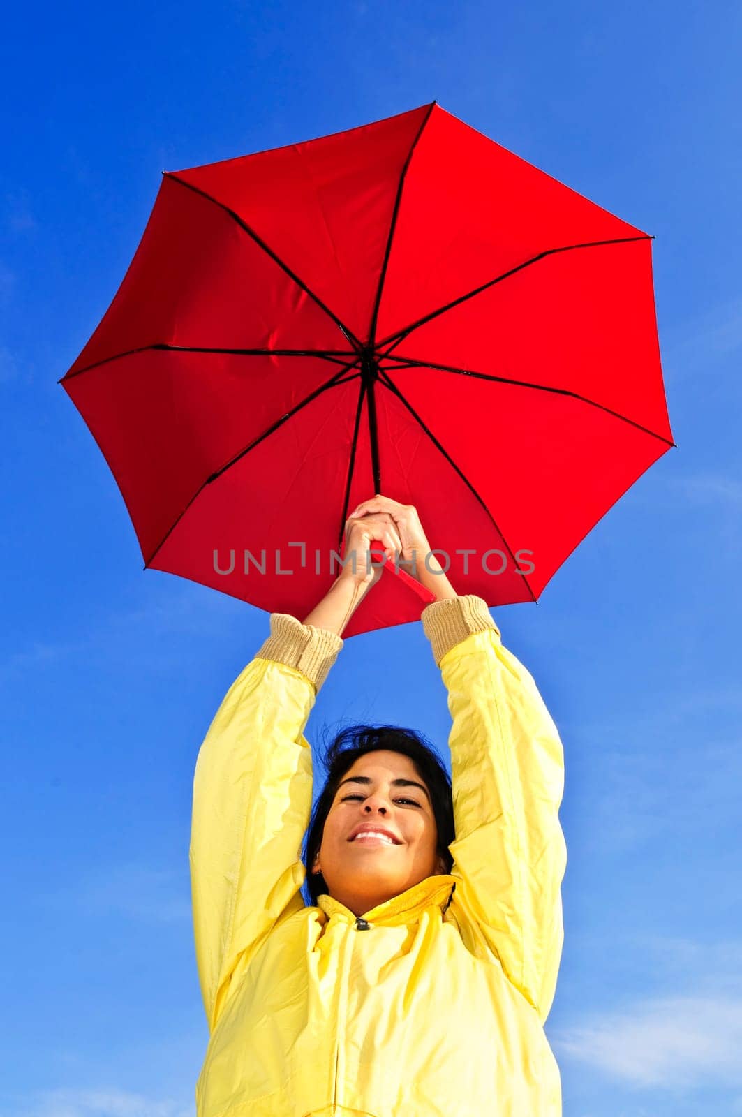 Beautiful young woman in raincoat with umbrella
