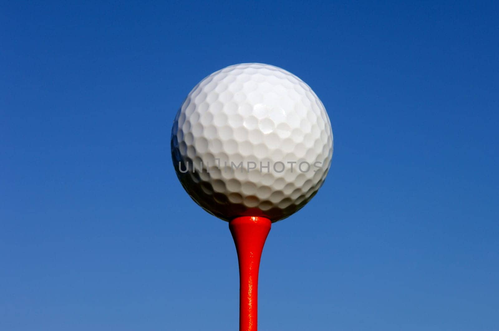 White Golf Ball on Red Tee
