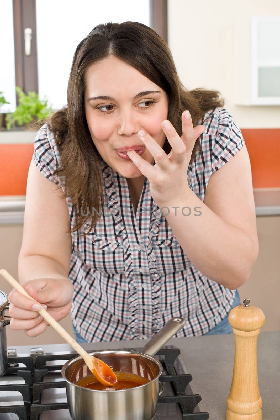 Cook - plus size woman tasting Italian tomato sauce