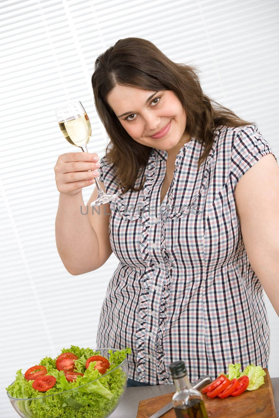 Cook - Plus size happy woman preparing salad in kitchen