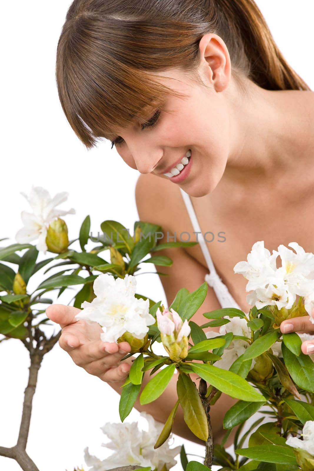 Portrait of woman smelling blossom of Rhododendron flower