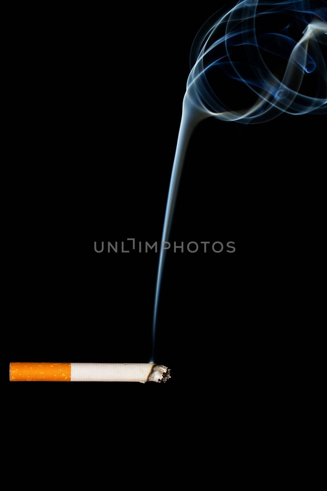 burning cigarette in front of black