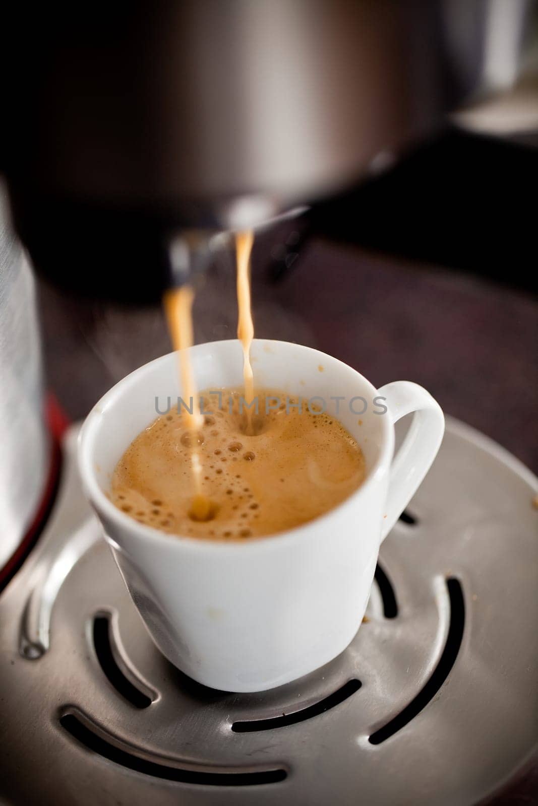 Coffee maker pouring hot espresso