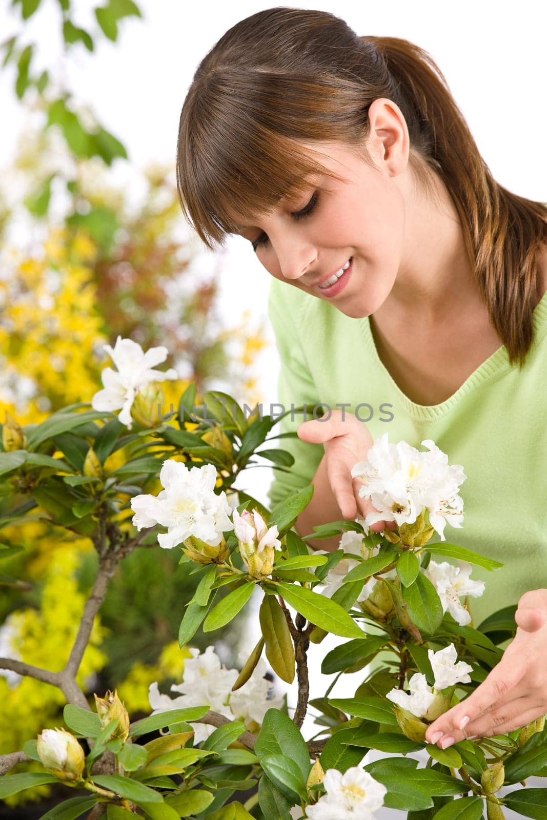 Portrait of woman smelling blossom of Rhododendron flower