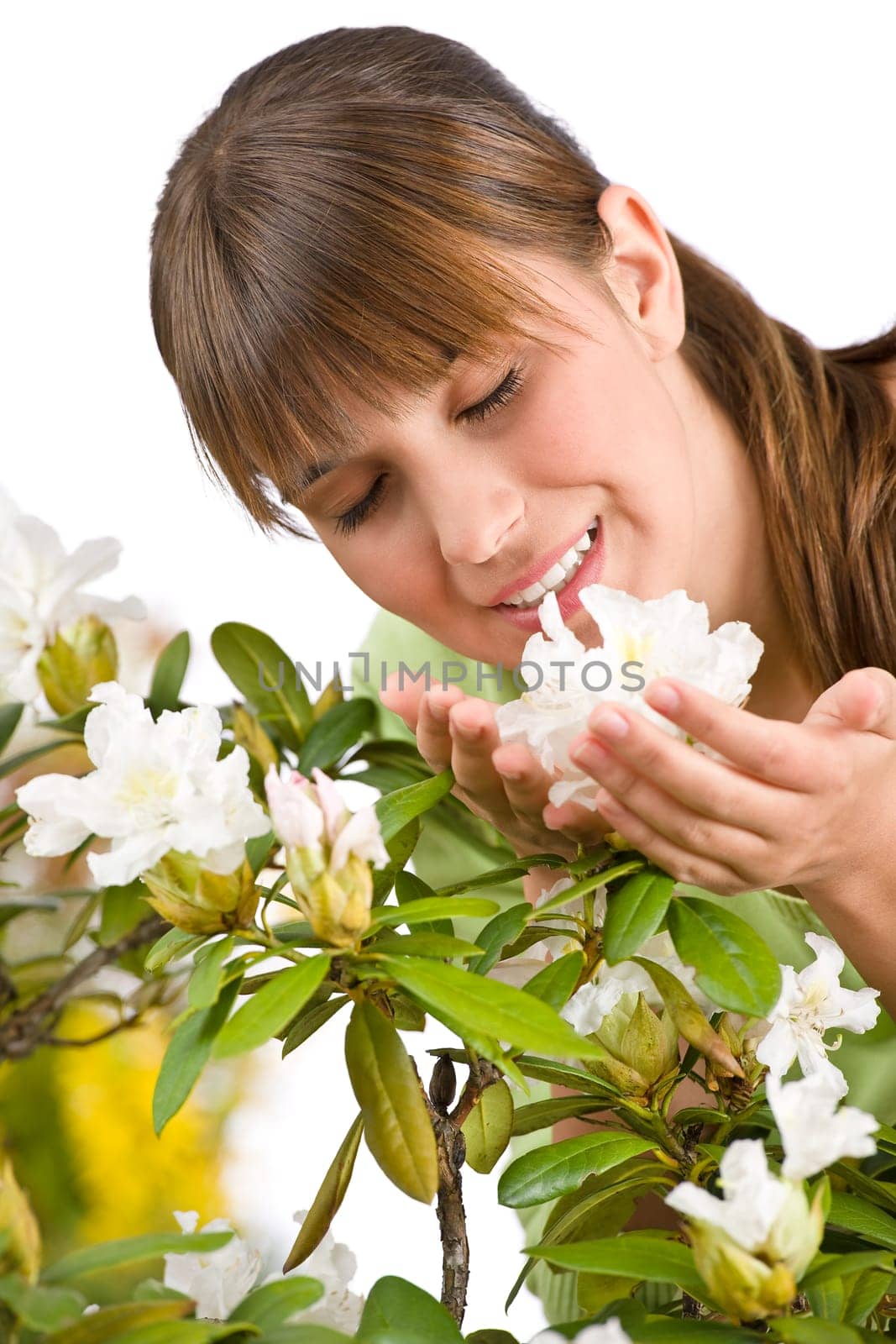 Portrait of woman smelling blossom of Rhododendron flower