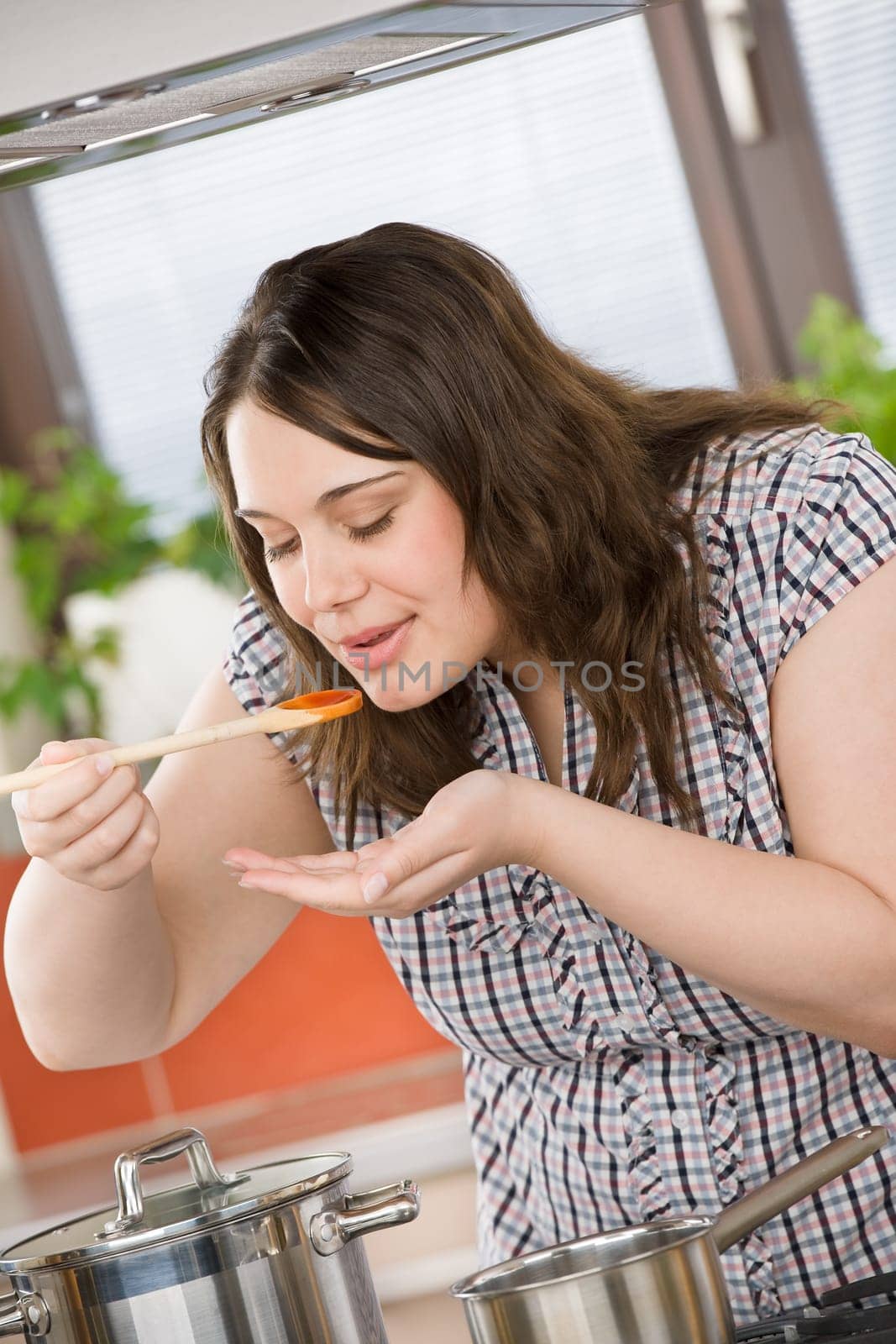 Cook - plus size woman tasting Italian tomato sauce