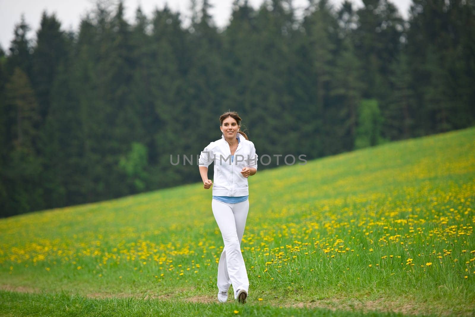 Jogging - sportive woman running on road in nature