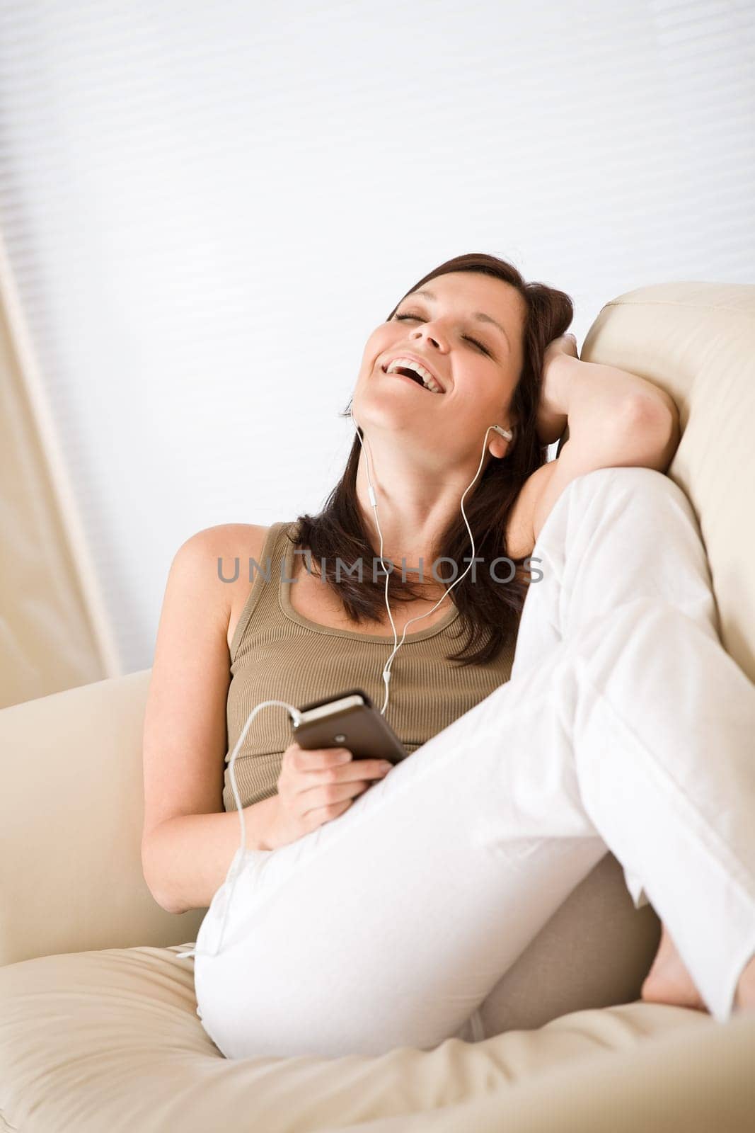 Woman holding music player listening with earbuds home