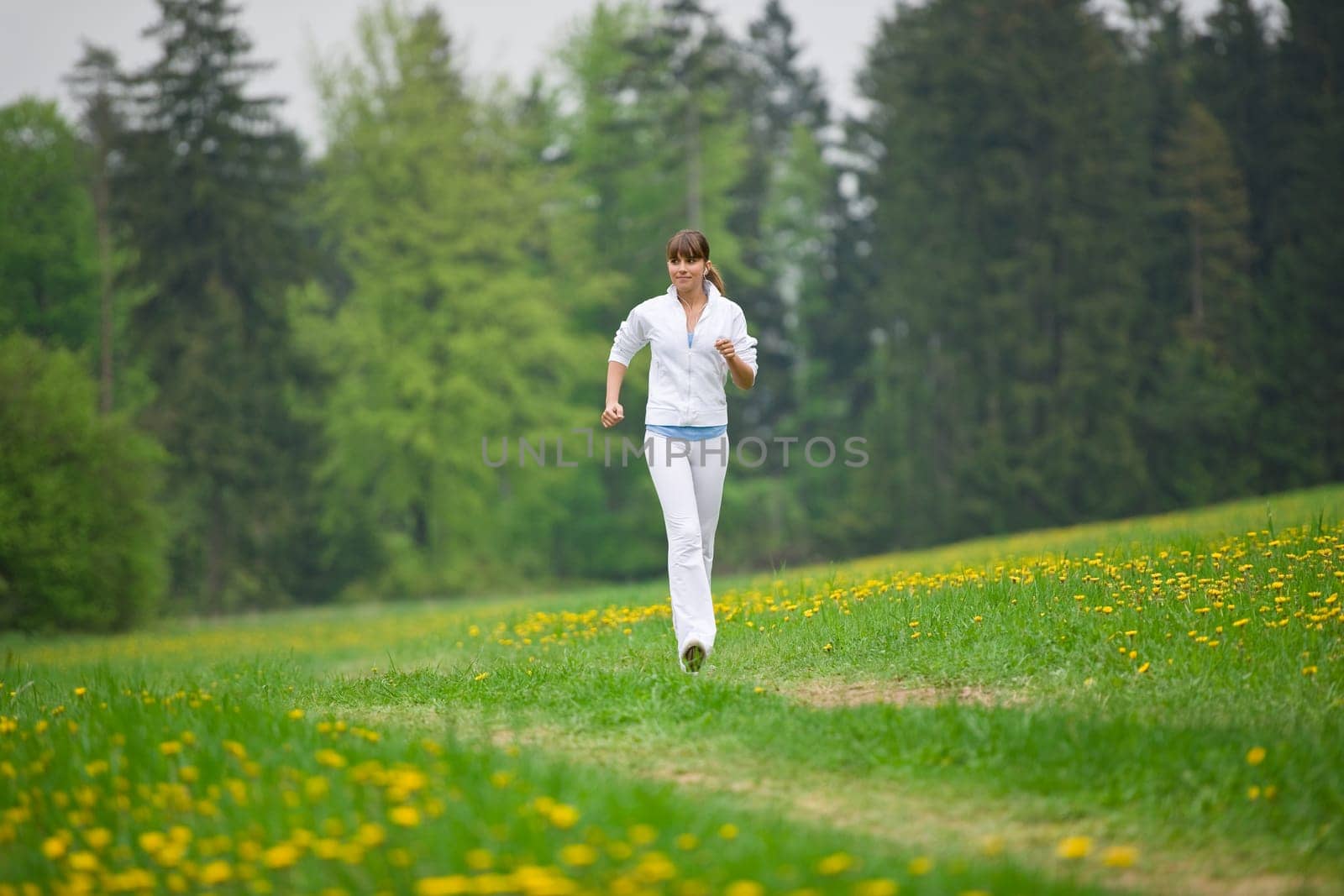 Jogging - sportive woman running on road in nature