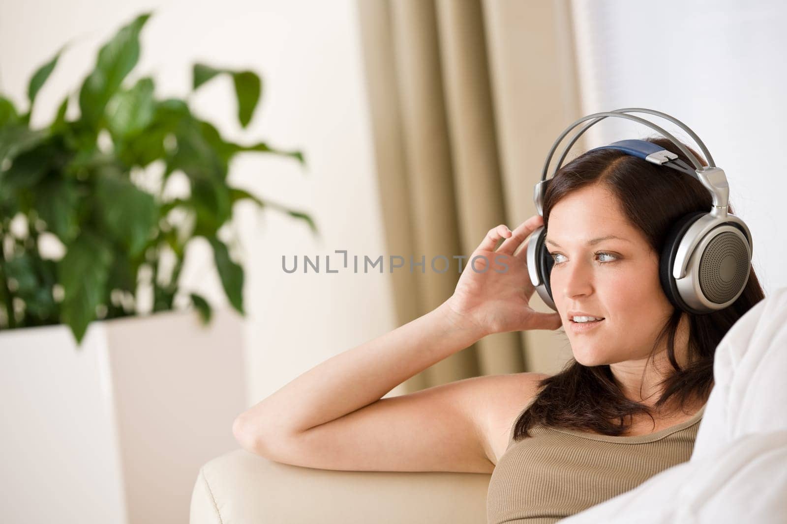 Woman with headphones listen to music in lounge