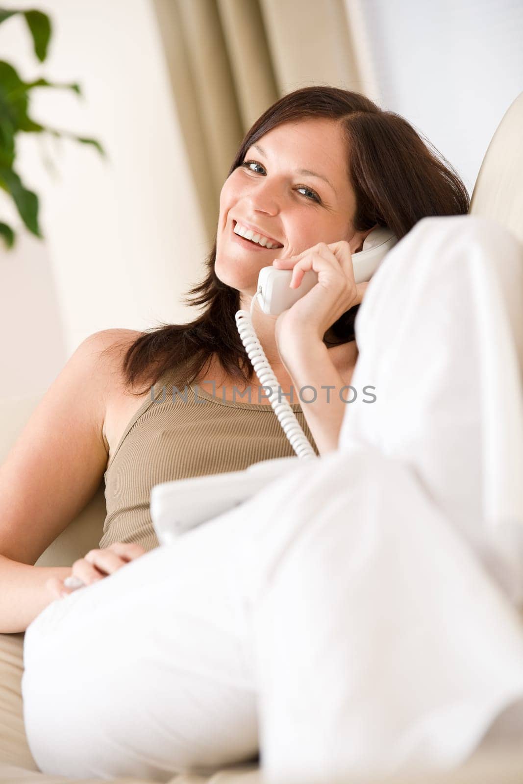 On the phone home Young woman calling in lounge