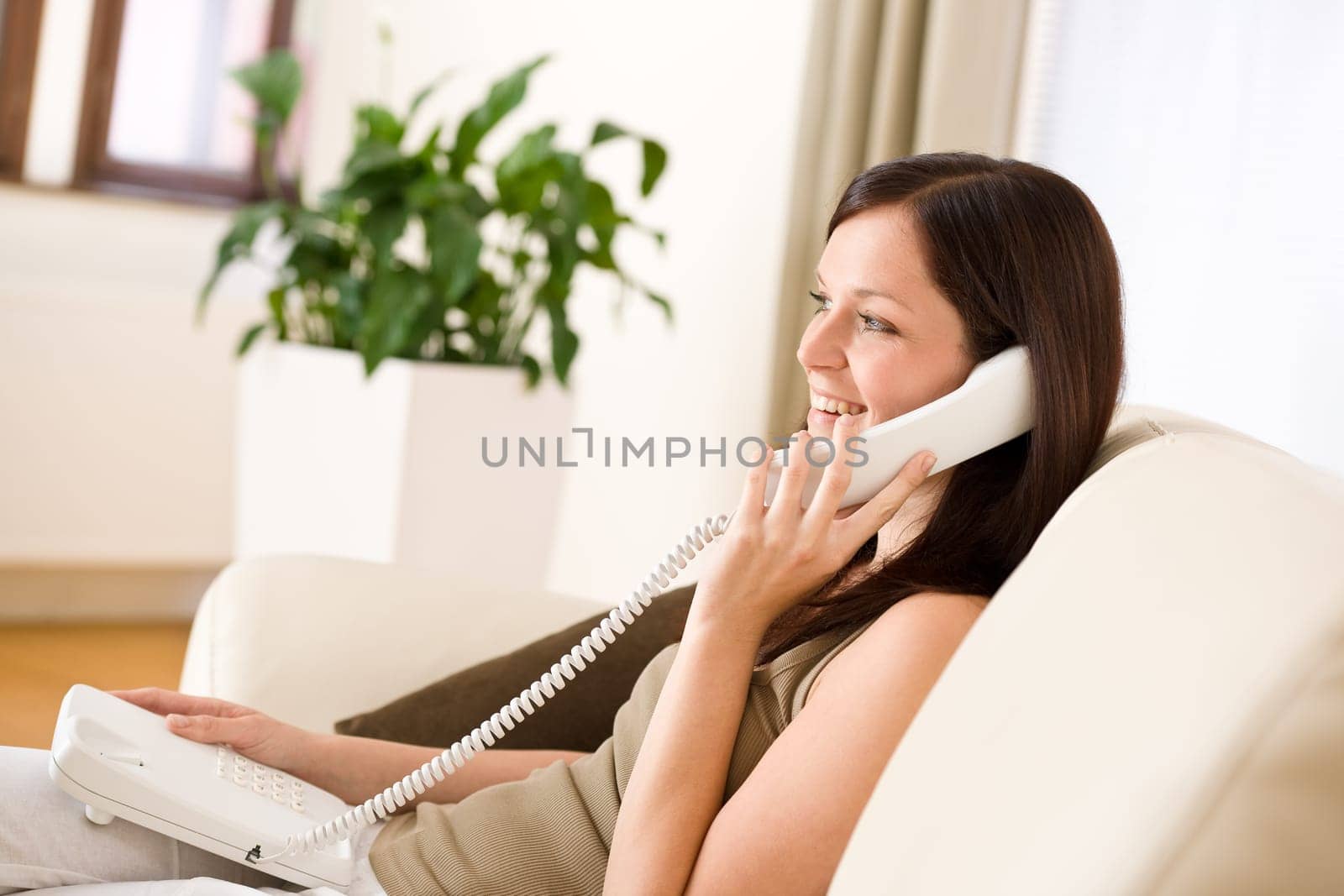 On the phone home Young woman calling in lounge