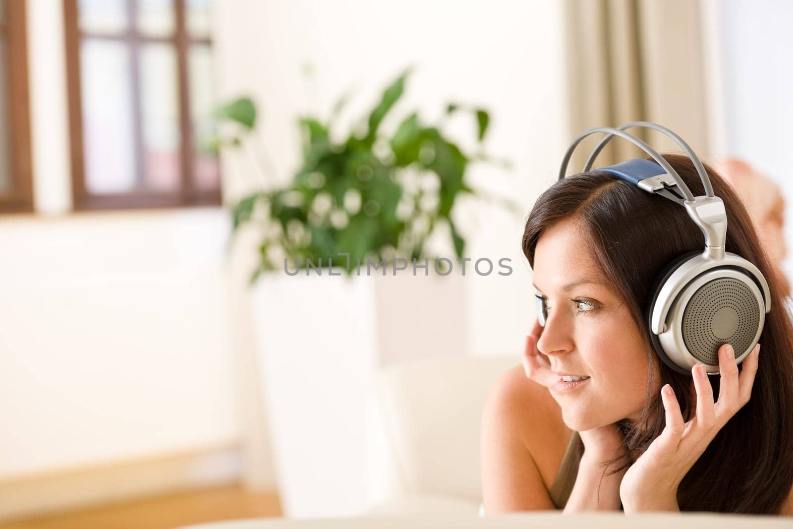 Woman with headphones listen to music in lounge