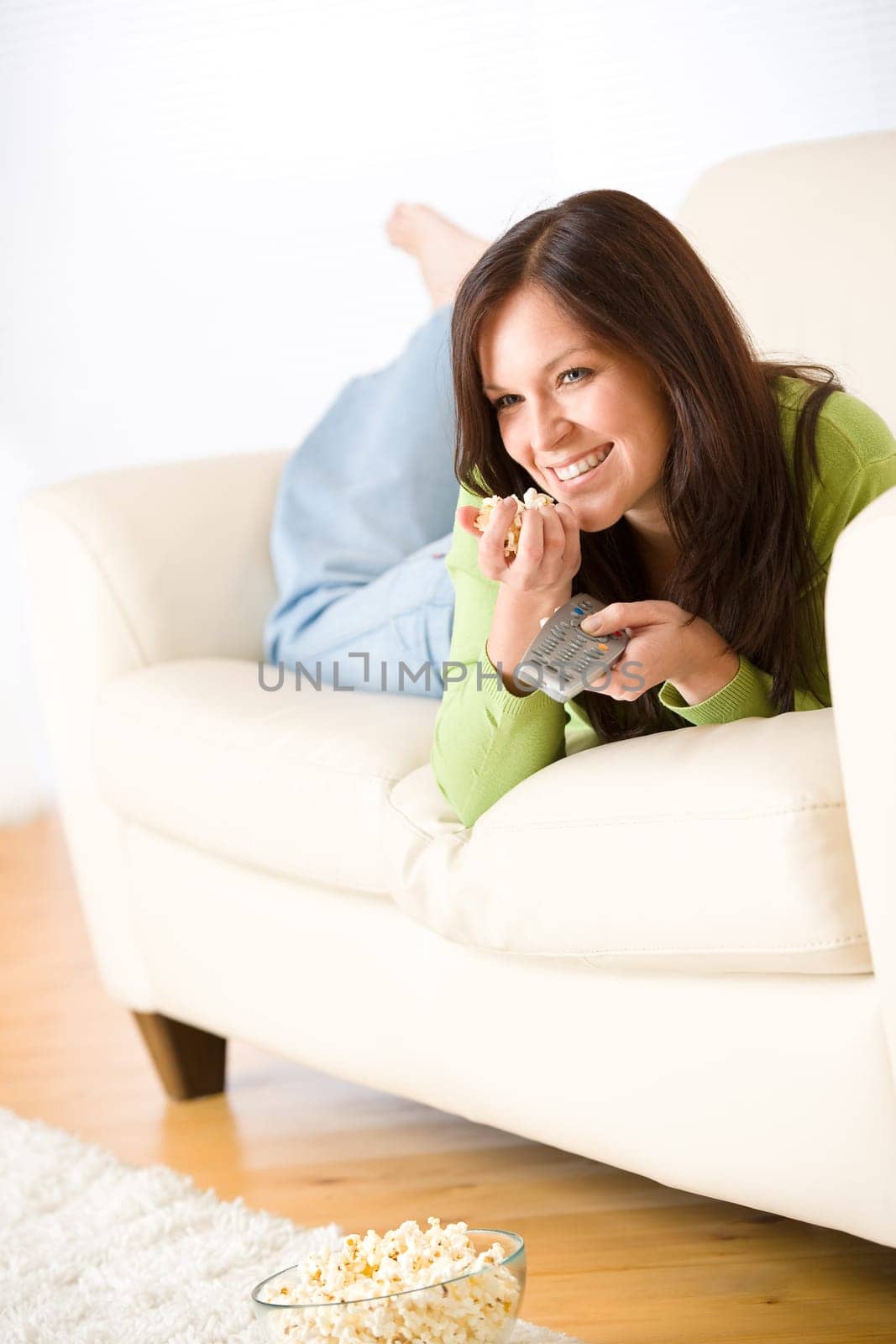 Woman watching television with popcorn in living room