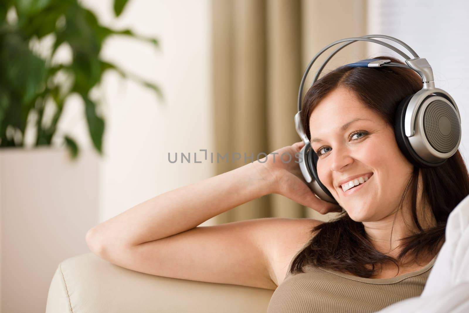 Woman with headphones listen to music  in lounge