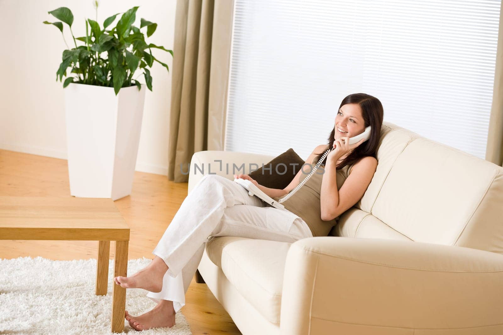 On the phone home Young woman calling in lounge