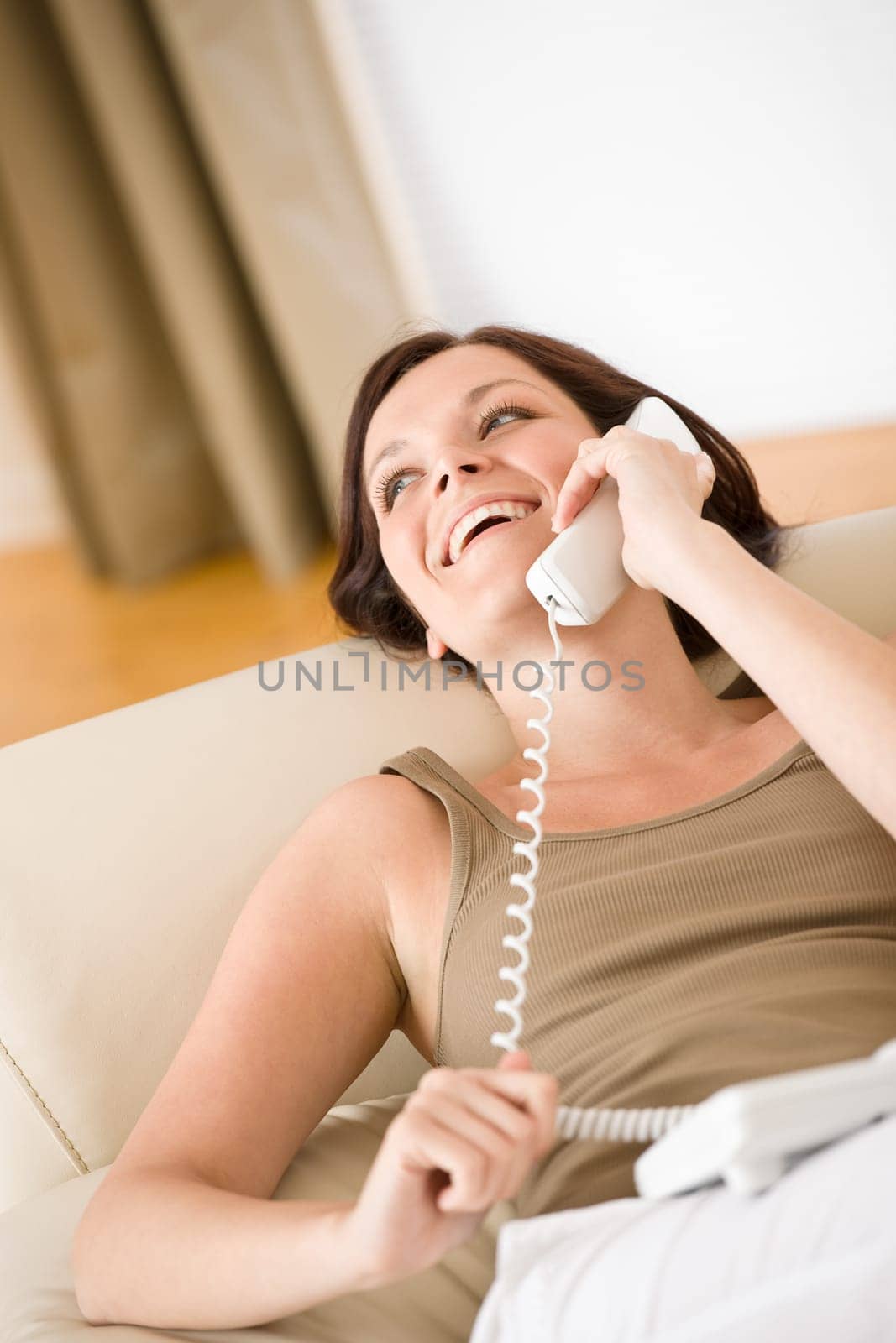 On the phone home Smiling woman on sofa calling