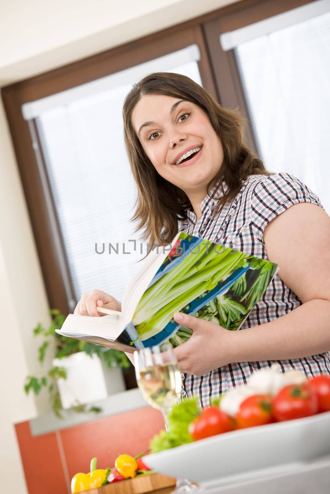 Cook - Plus size happy woman holding cookbook