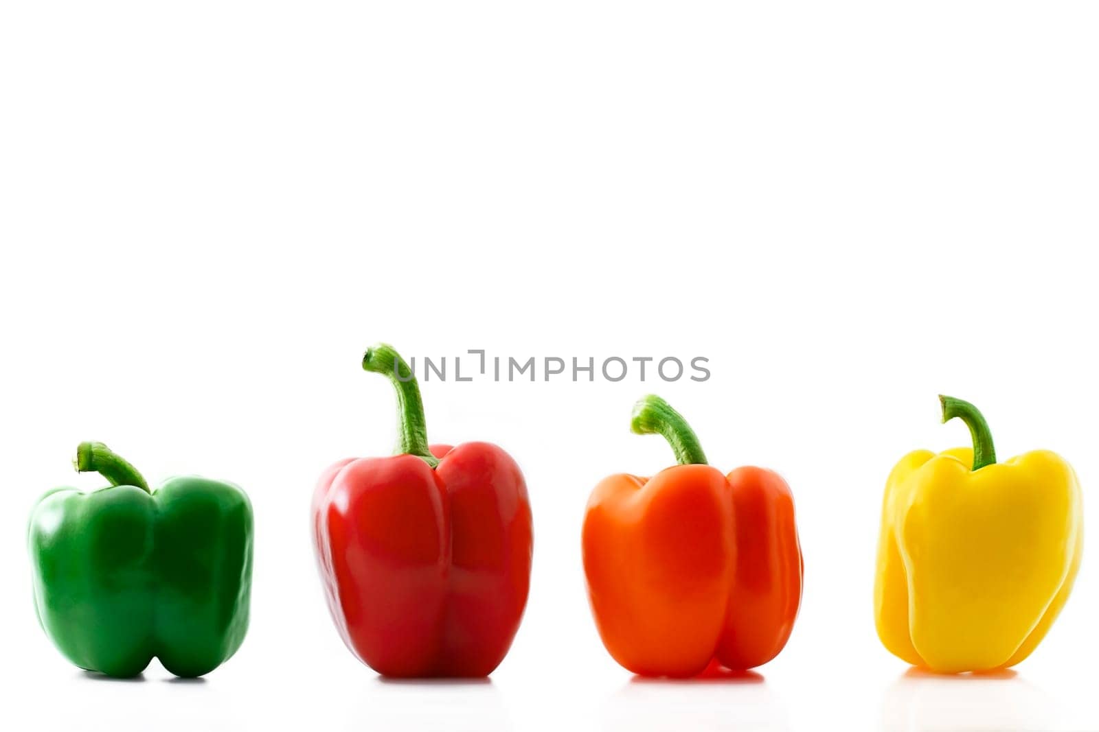 Four colored peppers in a row