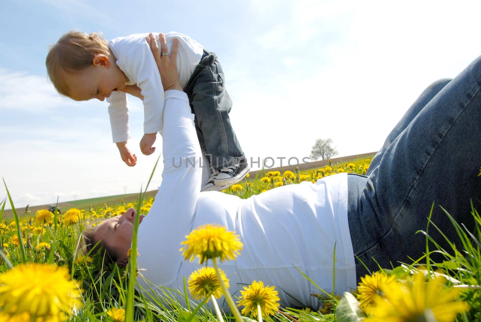Mother and toddler in dandelion field