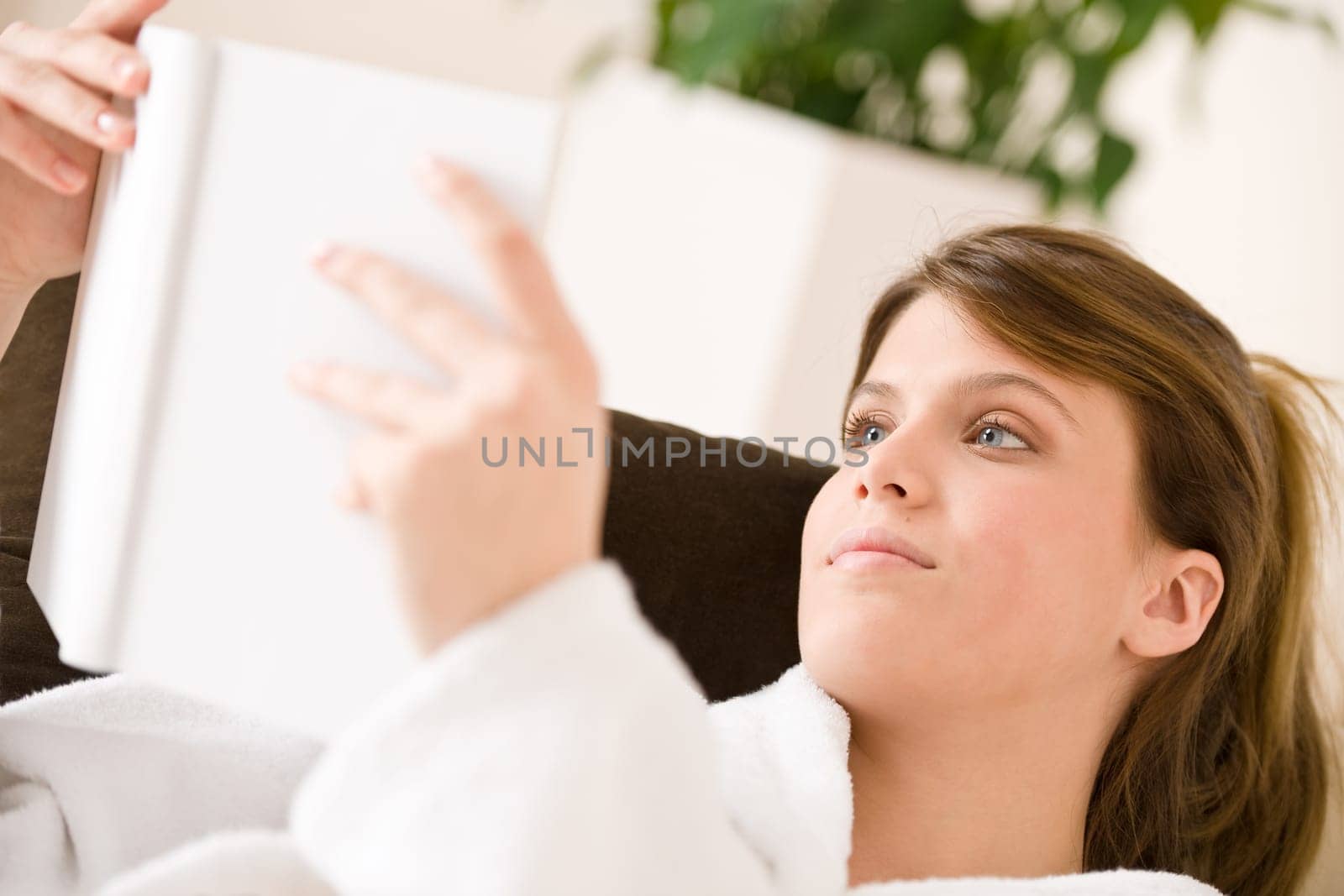 Young woman bathrobe reading book