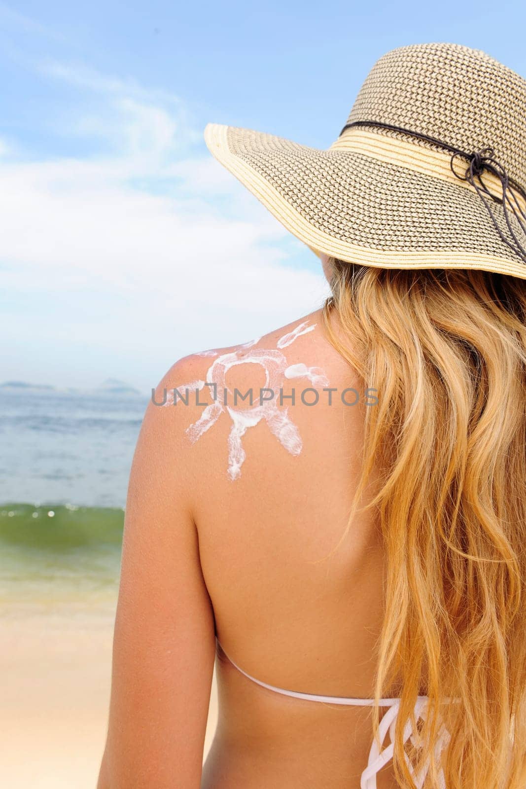 Woman applying sunscreen on the beach
