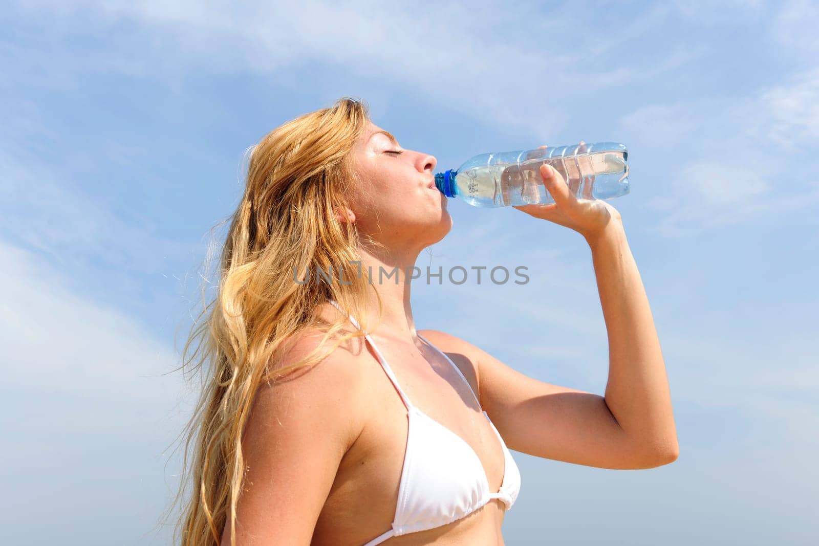 Woman drinking coconut water on the beach