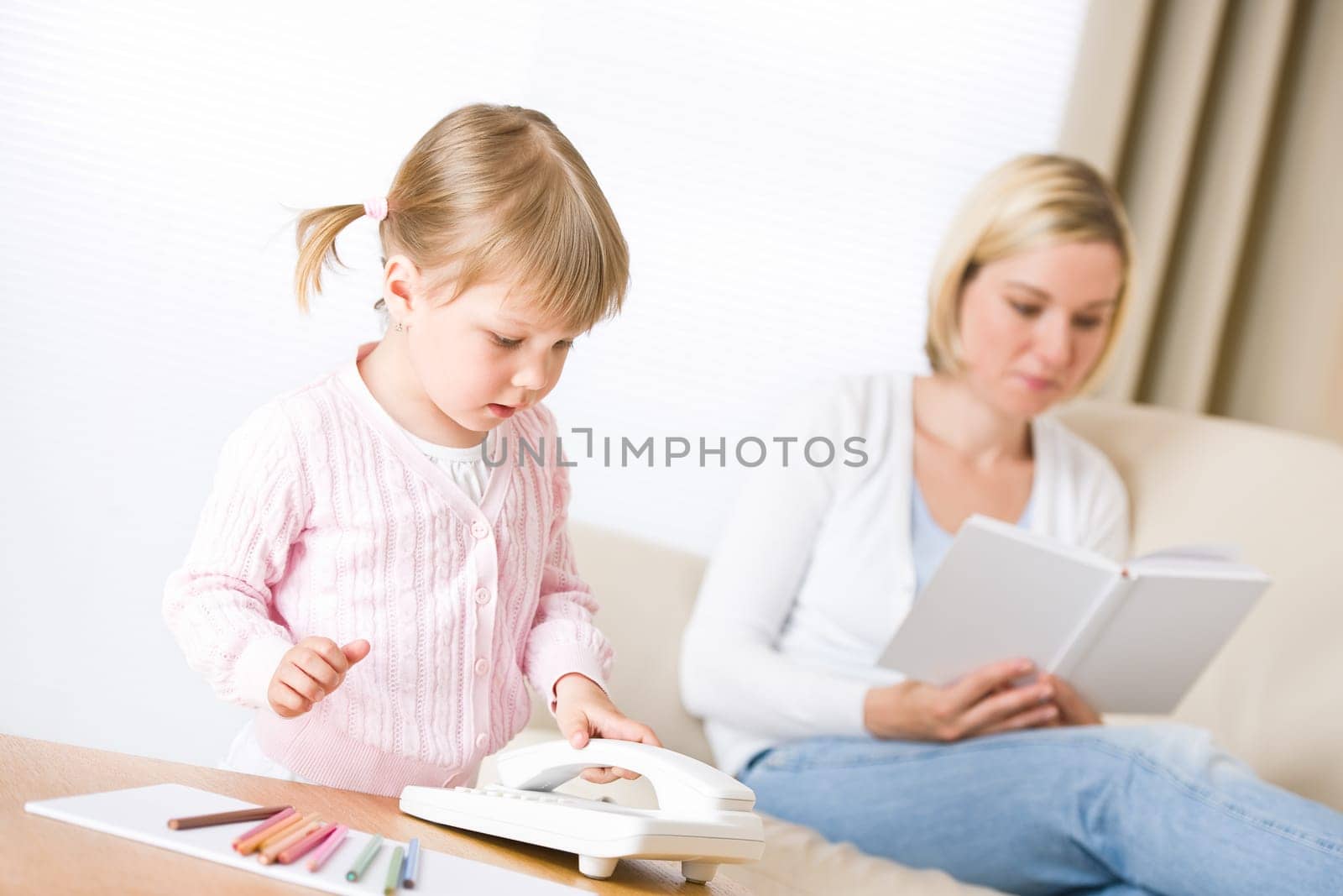 Little girl on phone in living room