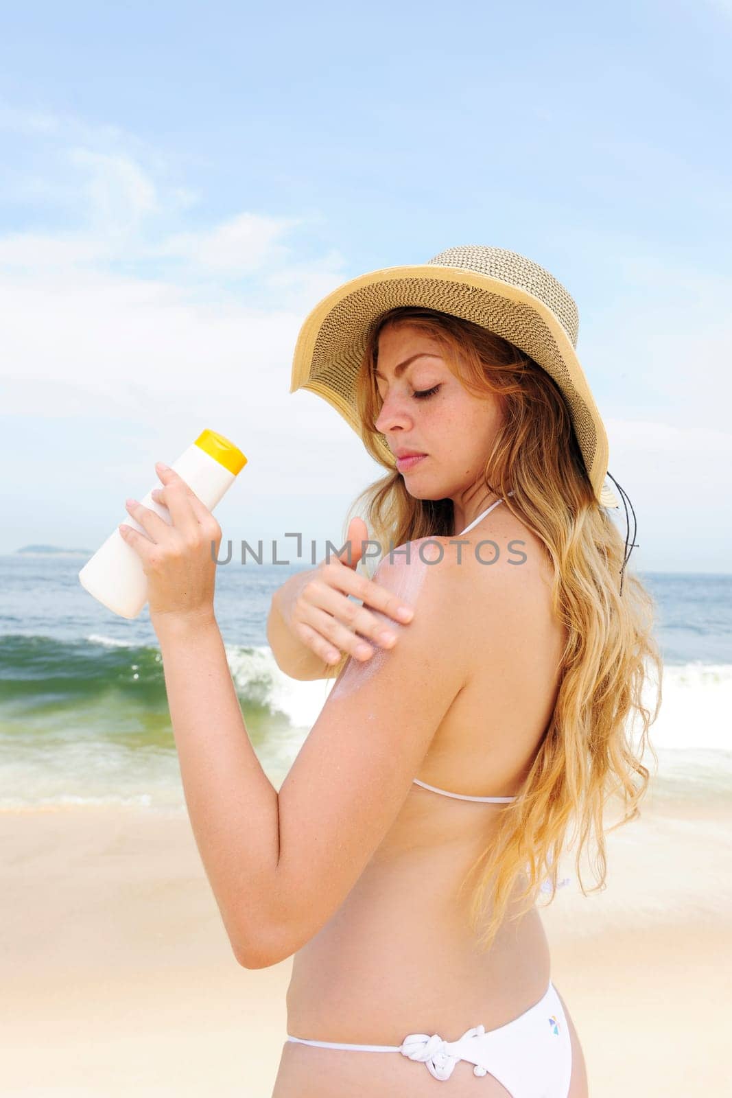 Woman applying sunscreen on the beach