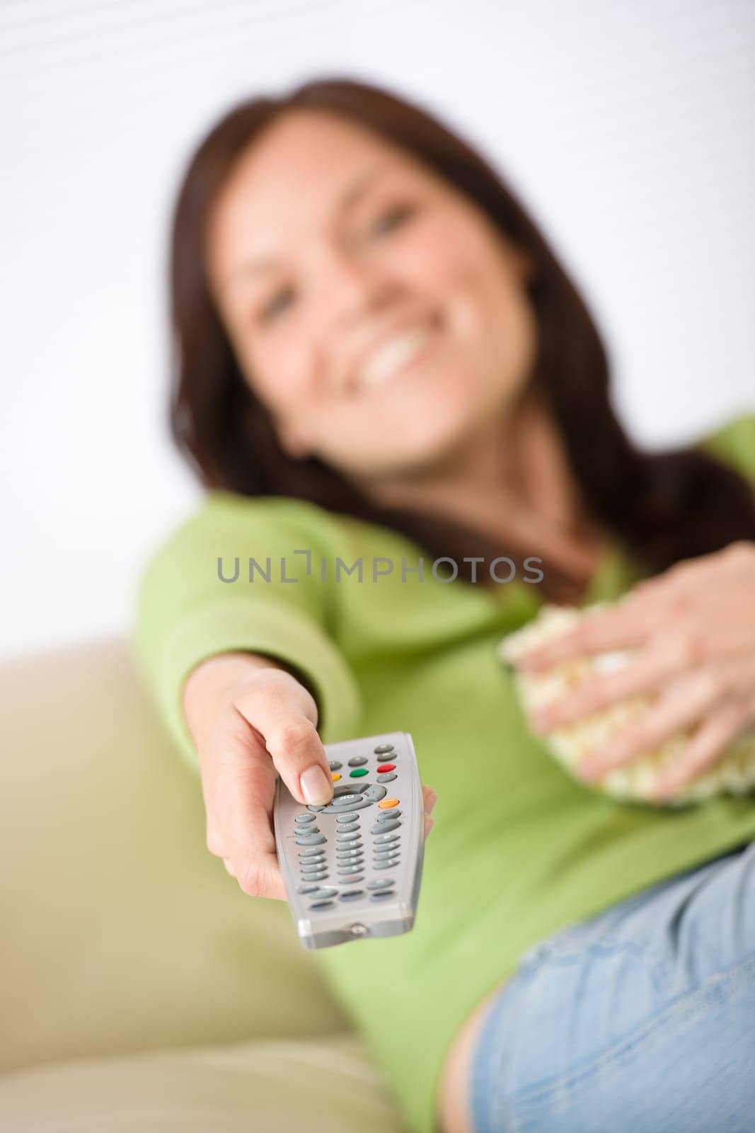 Woman pointing with television remote control