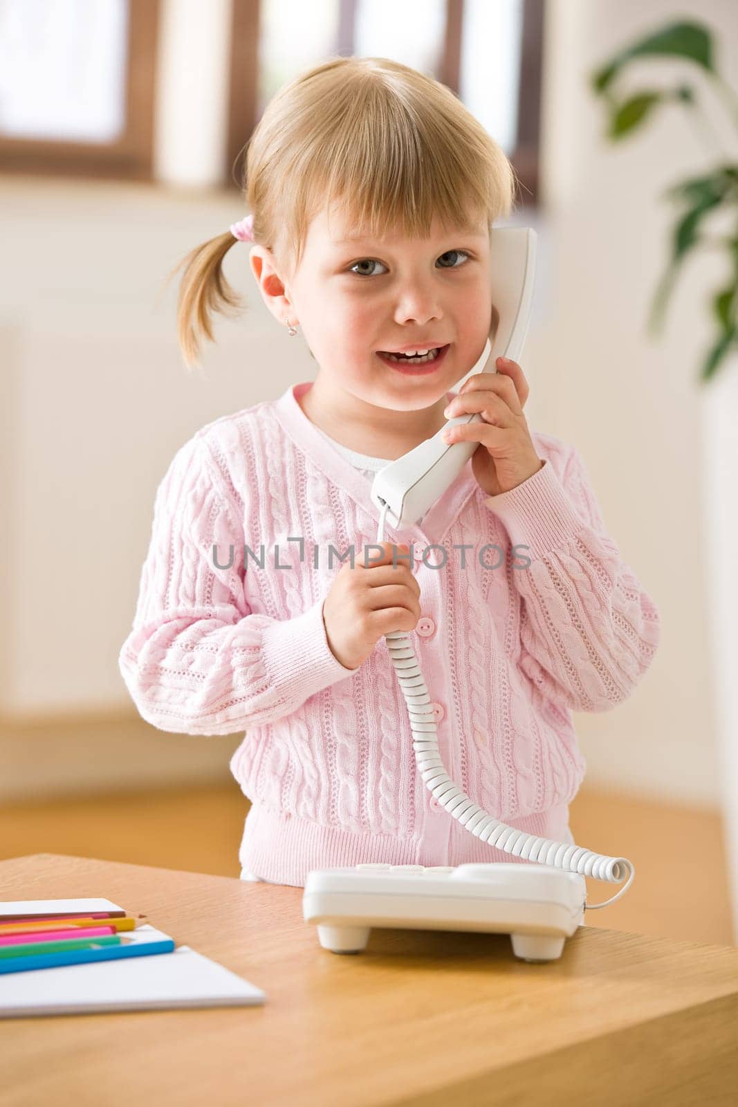 Smiling little girl on phone in lounge