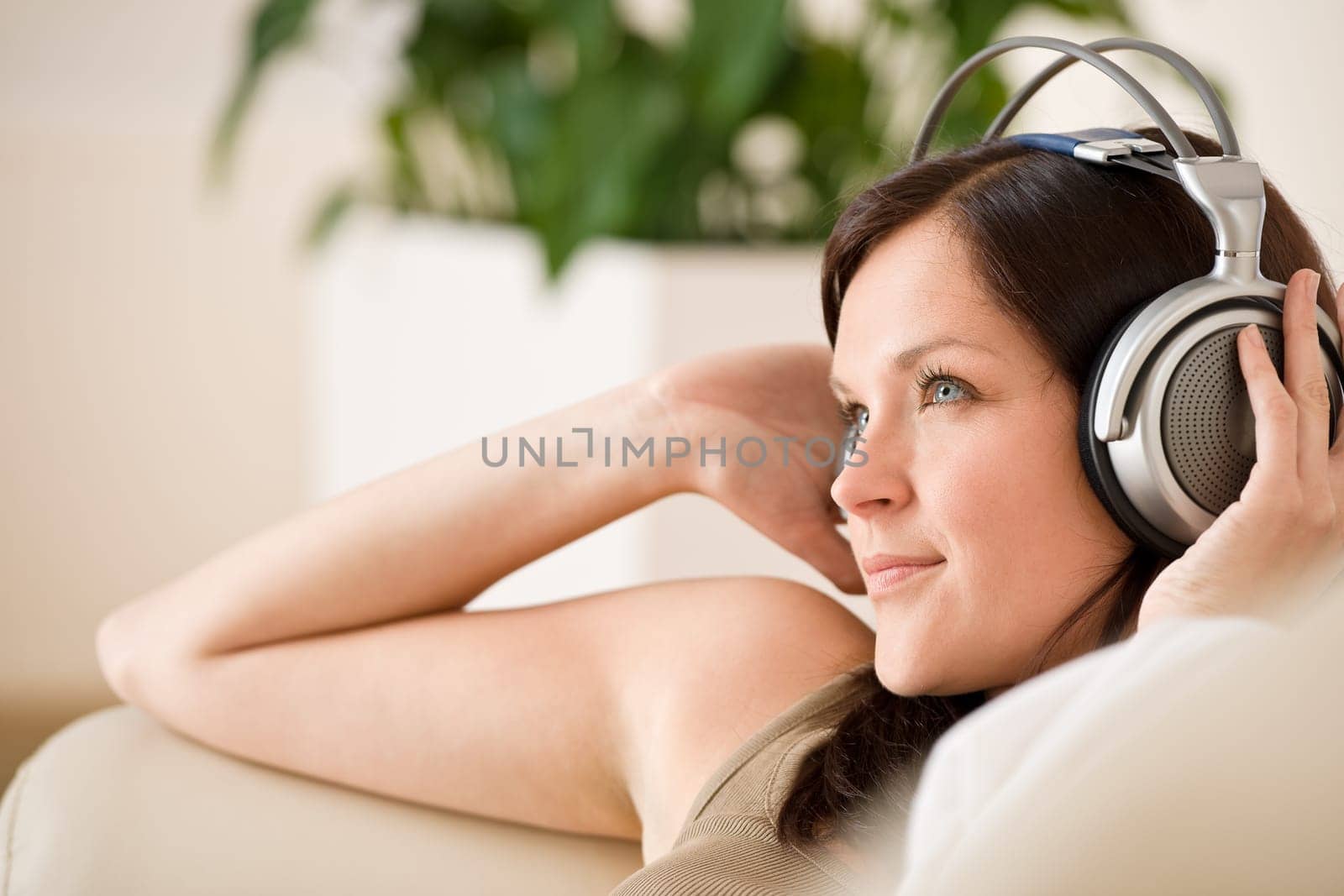 Smiling woman with headphones  listen to music in lounge
