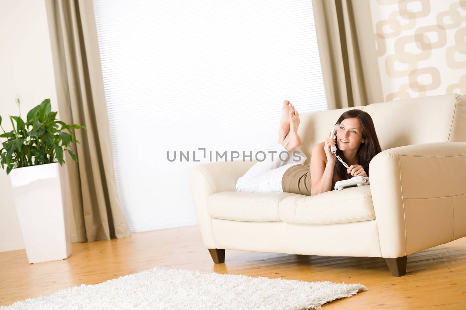On the phone young woman calling in lounge