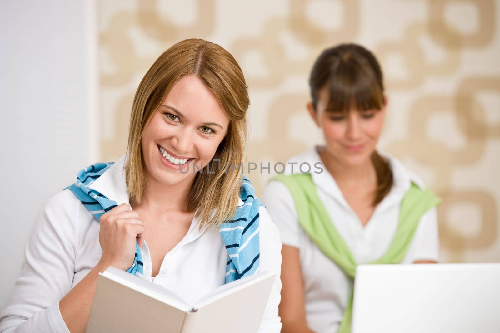 Student at home - two woman with book and laptop