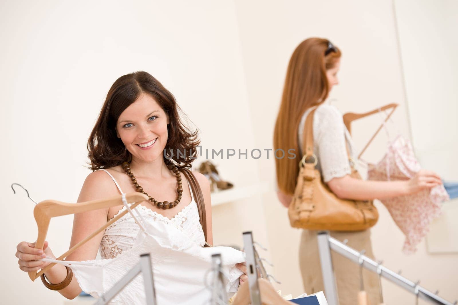 Fashion shopping - Two Happy woman choose sale clothes