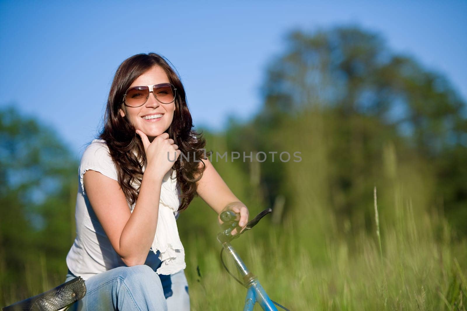 Woman with old-fashioned bike in meadow